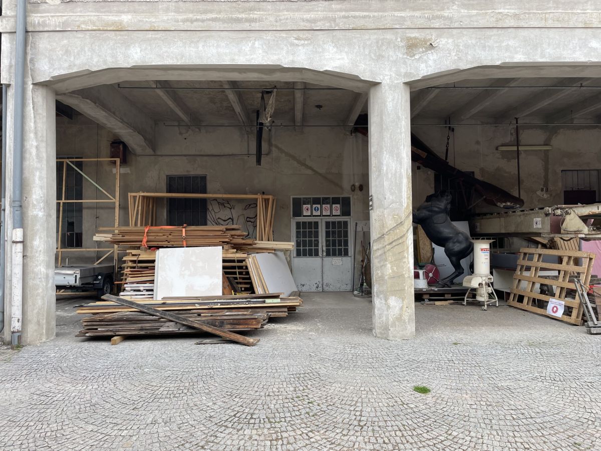 Kunstobjekt aus einer Plastikfigur eines Pferdes in einer Umgebung aus Beton und Holz.